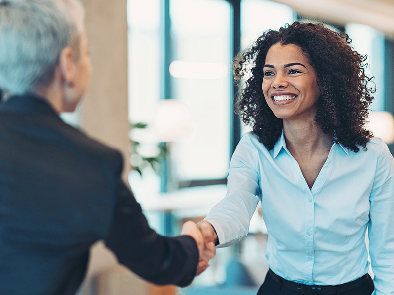 Smiling businesswoman greeting a colleague on a meeting